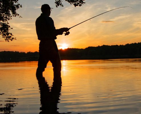 Someone flyfishing at sunset. Flyfishing is a local activity to participate in when you buy Carson City, NV real estate